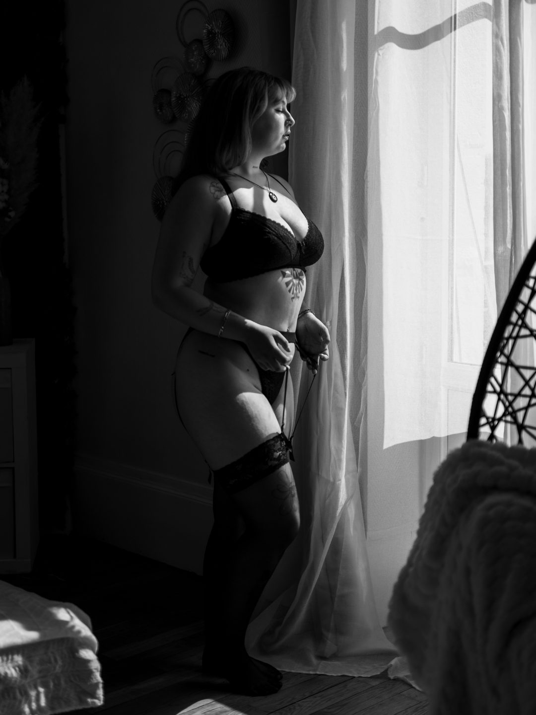 Photographe boudoir en Bourgogne, portrait en noir et blanc devant une fenêtre